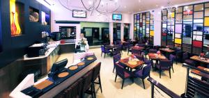 Garden Route Hotel في خليج موسيل: مطعم بطاولات وكراسي وبار