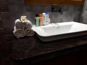 eine Badezimmertheke mit einem weißen Waschbecken und Handtüchern in der Unterkunft Luxury Villa with BB Free WI-FI in Bentota