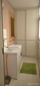 a bathroom with a sink and a washing machine at Panorama Beach House in Mascali
