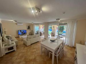 a living room with a white table and a couch at Villa with private pool and beautiful garden in Los Cristianos