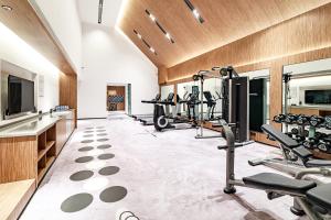 a fitness room with treadmills and elliptical machines at UrCove by HYATT Nanjing South Railway Station in Nanjing
