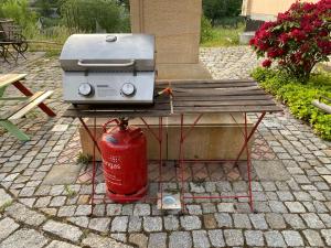 einen Grill auf einem Picknicktisch neben einem Hydranten in der Unterkunft Ferienwohnung WACHSTUBE mit 3 Schlafräumen im Rittergut Leppersdorf in Wachau
