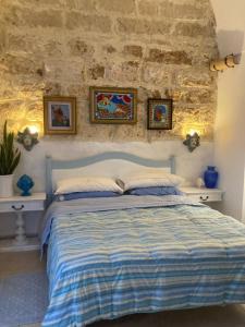 ein Schlafzimmer mit einem Bett mit einer Steinmauer in der Unterkunft Casa Bandini in Galatone