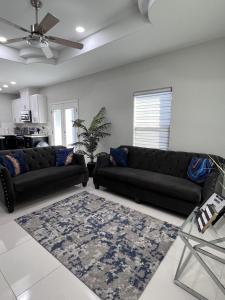 a living room with two black couches and a rug at Luxurious Modern Apartment #4 in Edinburg