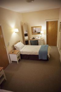 a hotel room with a bed and a desk at The Derg Arms B&B in Castlederg