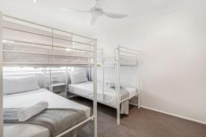 a room with two bunk beds and a ceiling at Palm Beach Haven in Gold Coast