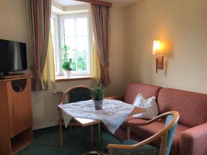 a living room with a table and a couch at Gasthof Botenwirt in Faistenau