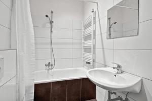 een witte badkamer met een wastafel en een douche bij 3-room apartment in Bochum