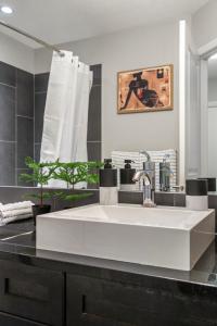 a large white sink in a black kitchen at City View 1BR Downtown Calgary in Calgary