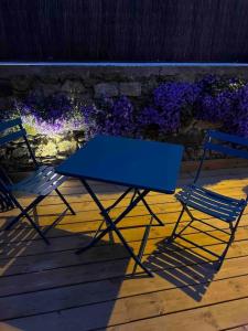 un tavolo blu e due sedie su una terrazza di legno di Maison Chaleureuse a Pléneuf-Val-André