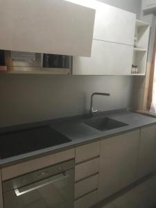 a kitchen with a sink and white cabinets at La casa di Ale. Foligno in Colfiorito