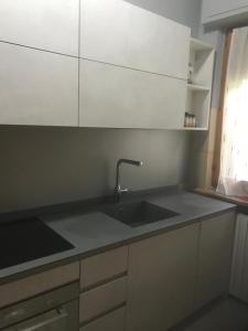 a kitchen with a sink and white cabinets at La casa di Ale. Foligno in Colfiorito