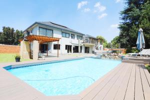 a large swimming pool in front of a house at Villa Portia in Johannesburg