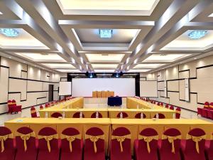una grande sala conferenze con tavoli e sedie di Sahid Azizah Syariah Hotel and Convention Kendari a Lepoleop