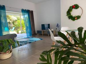 a living room with a couch and a table with a plant at Ana iti Lodge PAEA Tahiti in Paea