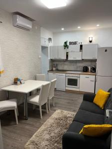 a living room with a couch and a table and a kitchen at Apartman Plasse in Rijeka