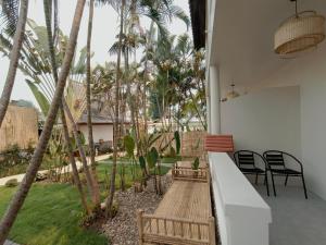 a patio with chairs and palm trees in a house at 23 PAI HOUSE boutique hotel in Pai