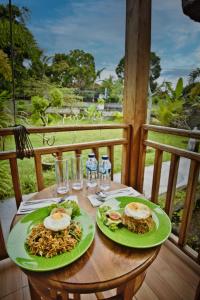a table with two plates of food on a balcony at Tegal Besung Cottage in Nusa Penida
