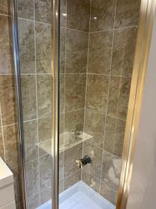 a shower with a glass door in a bathroom at Most Easterly Guest House in Pakefield