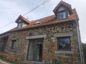 een stenen huis met drie ramen erop bij Equinoxe in Dragey