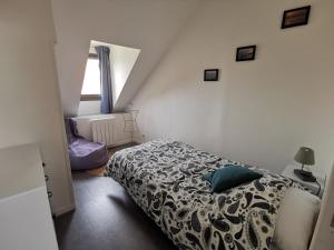 een kleine slaapkamer met een bed en een raam bij Equinoxe in Dragey