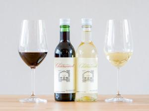 twee flessen wijn en twee glazen op een tafel bij Rakuten STAY VILLA Yatsugatake - 101 Stylish Design - in Hokuto