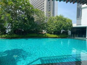 a large blue swimming pool in a city at Pearl Suria @ Old Klang Road - 2 Bedroom Home in Kuala Lumpur