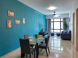a dining room with a blue wall and a table and chairs at Pearl Suria @ Old Klang Road - 2 Bedroom Home in Kuala Lumpur