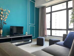 a living room with a couch and a flat screen tv at Pearl Suria @ Old Klang Road - 2 Bedroom Home in Kuala Lumpur