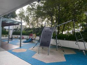 an outdoor playground with a slide and swings at Pearl Suria @ Old Klang Road - 2 Bedroom Home in Kuala Lumpur