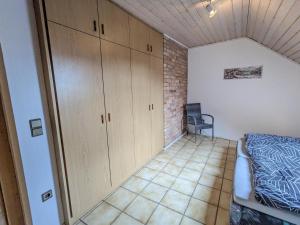 a bedroom with wooden cabinets and a bed at Ferienwohnung Madenburgblick in Eschbach