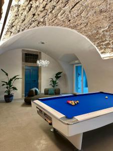 a pool table in a room with a stone wall at Vulcano Palace in Castro