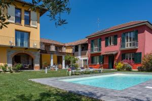 a villa with a swimming pool in front of a building at Villa La Martina in Canelli