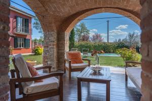 a patio with an archway with chairs and a table at Villa La Martina in Canelli