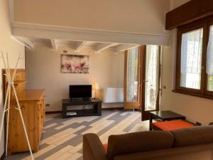 a living room with a couch and a tv at Villa Tiziana Typ T1 in Crone