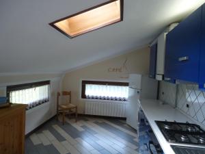 a kitchen with blue cabinets and a skylight at Villa Tiziana Typ T1 in Crone