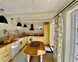 a large kitchen with a wooden table in it at Exklusivt gästhus på anrik prästgård in Sösdala