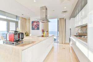 a kitchen with white counters and a large window at Posh 2 BR Oceanfront Apt in the Heart of Bluewaters Island in Dubai