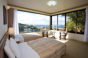 a hotel room with two beds and a large window at Hotel Tenzankaku Kaiyutei in Shirahama