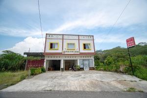 um edifício na berma da estrada em RedDoorz Syariah near Rembele Airport Bener Meriah em Tingkeum