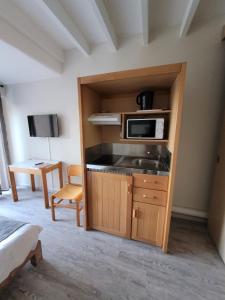 a kitchen with a sink and a microwave in a room at Le Pescadou in Martigues