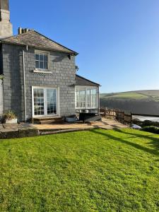 a house with a large lawn in front of it at NEW 2023 Modern Luxury Holiday Home on the Beach in Devon - Free Parking, Pets Welcome, Sleeps 10 in Plymouth