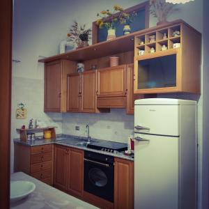 a kitchen with wooden cabinets and a white refrigerator at Antica Dimora 1848 in Biccari
