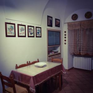 ein Esszimmer mit einem Tisch und einem TV in der Unterkunft Antica Dimora 1848 in Biccari
