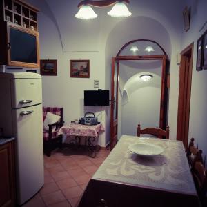 eine Küche mit einem Tisch und einem weißen Kühlschrank in der Unterkunft Antica Dimora 1848 in Biccari