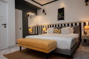 a bedroom with a large white bed and a bench at Richmonde Ananta Elite Luxurious Villa & Apartments,Goa in Baga