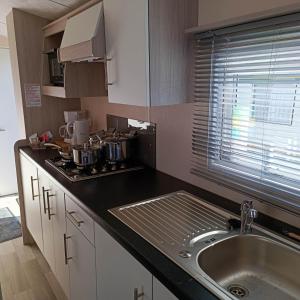 a kitchen with a sink and a counter top at Caravan Aan Zee Arnani in Middelkerke