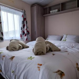 un dormitorio con dos animales de peluche tirados en una cama en Caravan Aan Zee Arnani, en Middelkerke