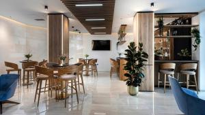 a bar with stools and tables in a restaurant at Grand Hotel Zagreb in Zagreb