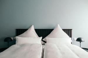 two white pillows on a bed in a bedroom at Moselhaus by Clüsserath-Wittmann in Trittenheim